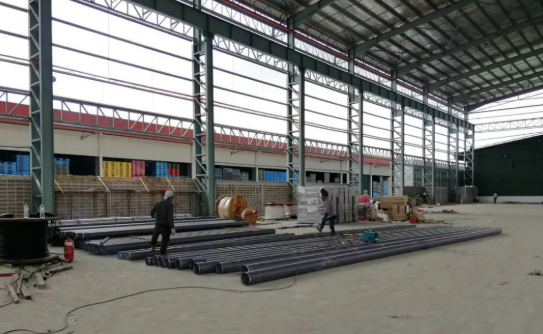 Steel-frame warehouse with stacked construction pipes